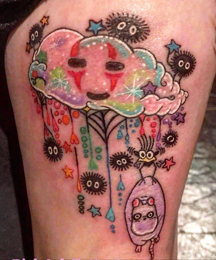 Colorful tattoo of a cloud, soot sprites, and a character in a teardrop shape on a leg